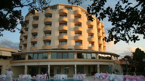 Un hotel con zona de piscina, varios balcones y una amplia fachada.