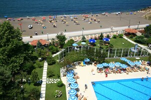 Una piscina techada, una piscina al aire libre de temporada, sombrillas
