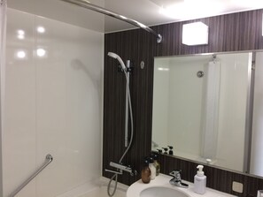 Een moderne badkamer met een inloopdouche, een grote spiegel en een wit wastafelmeubel.