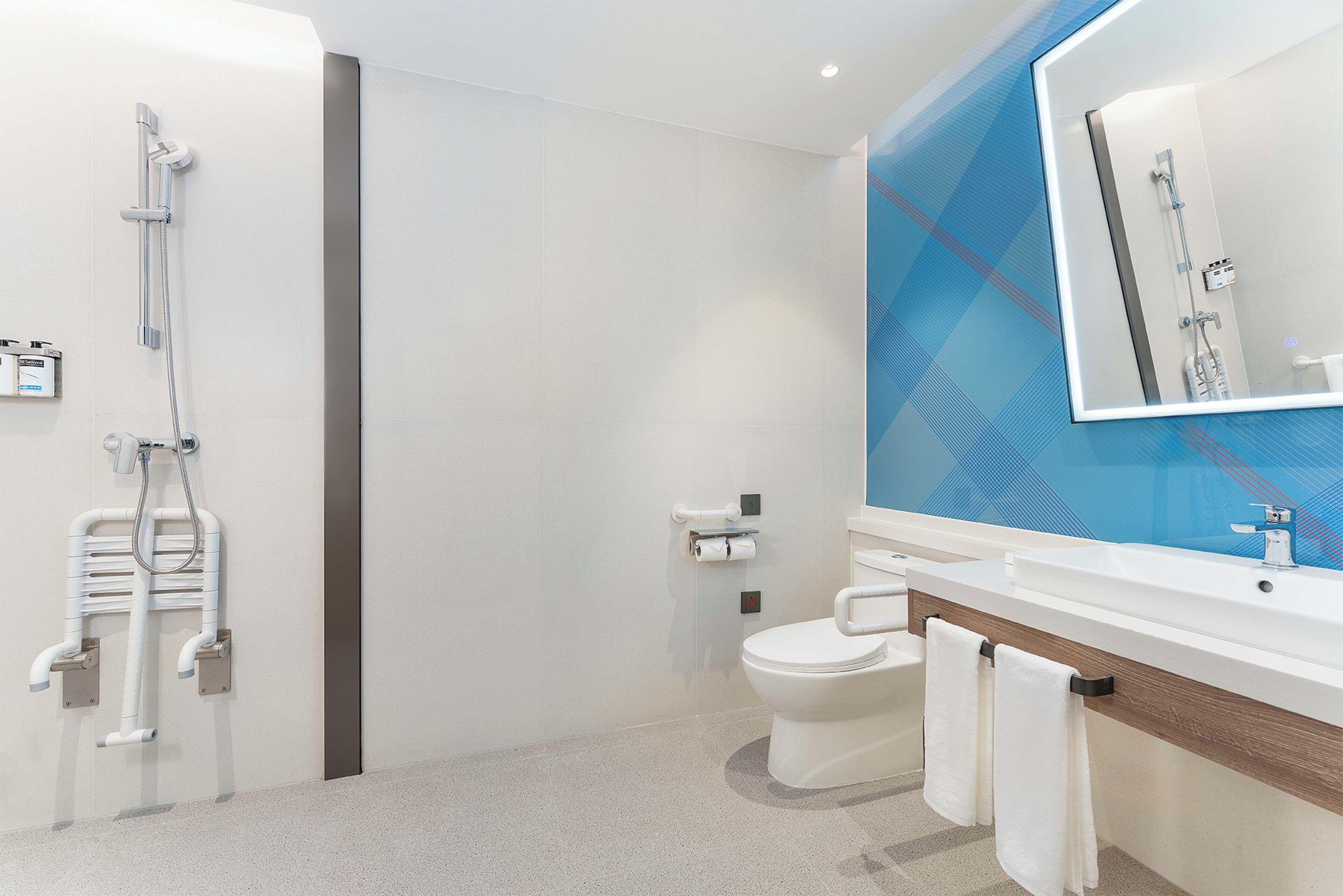 A modern bathroom with a shower, toilet, and sink.