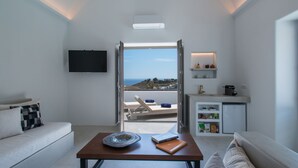 Una sala moderna con sofá, una mesita de centro y vistas al mar.