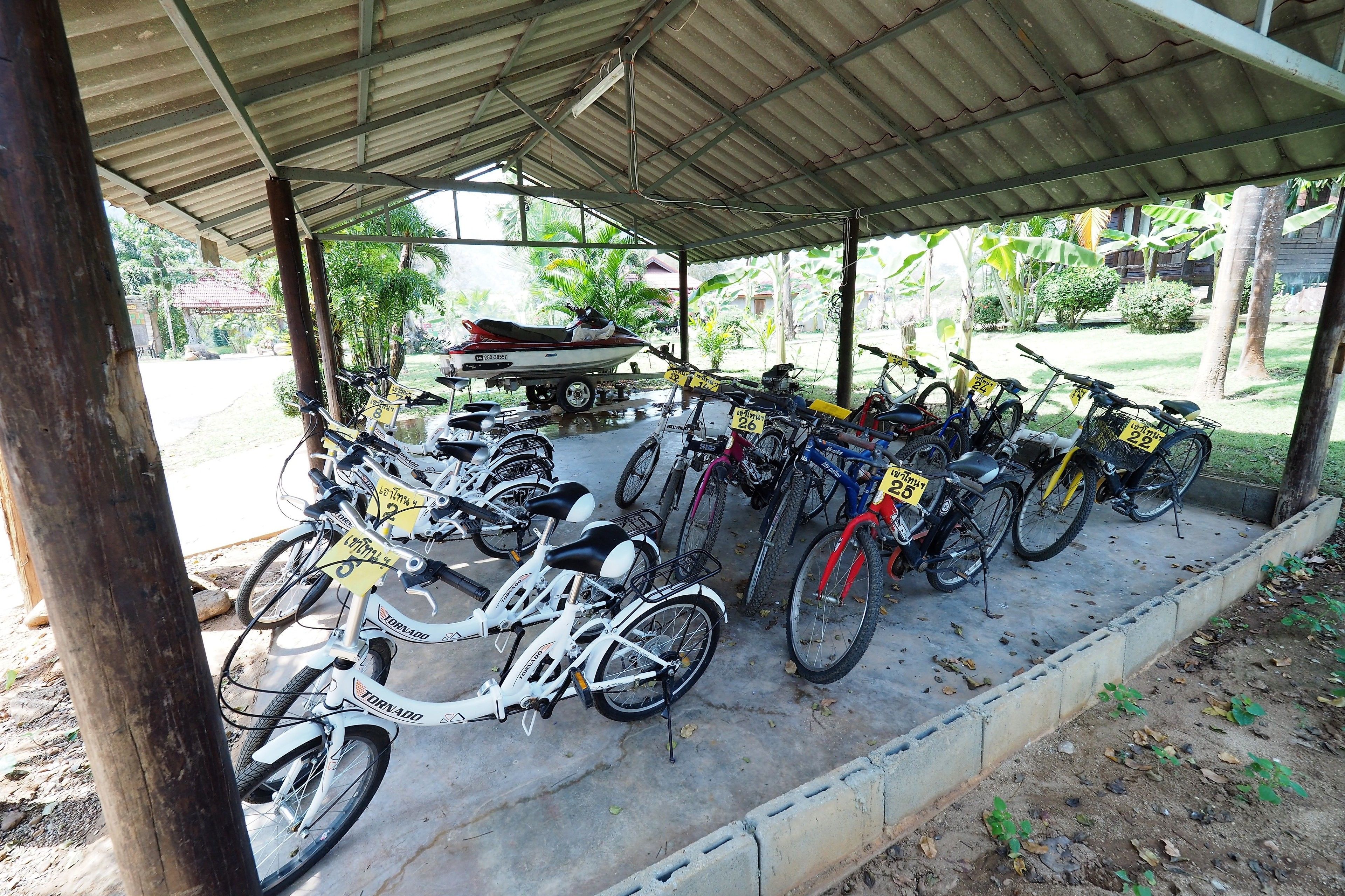 Un aparcamiento cubierto para bicicletas con diversas bicicletas y una motocicleta.