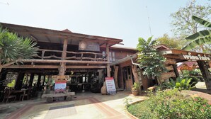 A rustic wooden building with a covered entrance and a signboard. - Khaothone River View Resort (Sai Yok)
