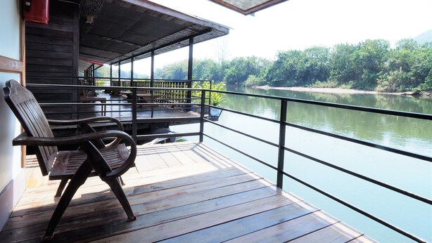 A wooden deck with a bench, overlooking a calm river and lush greenery. - Khaothone River View Resort (Sai Yok)