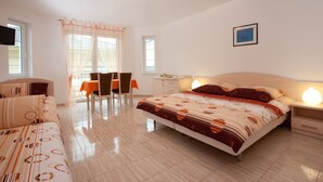 Un dormitorio con cama, escritorio, silla y televisor.
