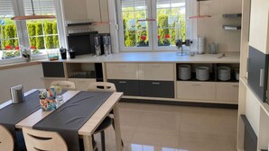 Una cocina moderna con comedor, ventanas amplias y vista a zonas verdes.