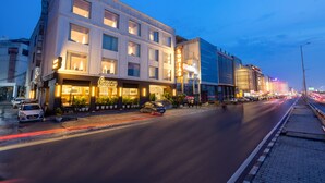 Un hotel con fachada moderna, varios pisos y una entrada bien iluminada.