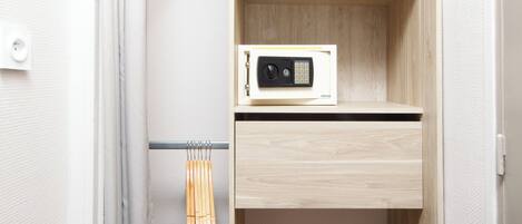 A walk-in closet with wooden shelves, a hanging rack, and a microwave.