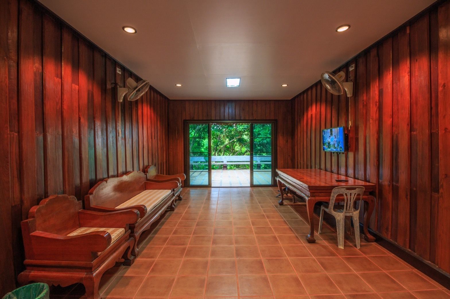 A room with wooden panel walls, a bench, a table, and chairs.