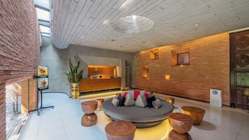 Eine moderne Lobby mit Empfangstresen, Sitzgelegenheiten und einer großen Pflanze.