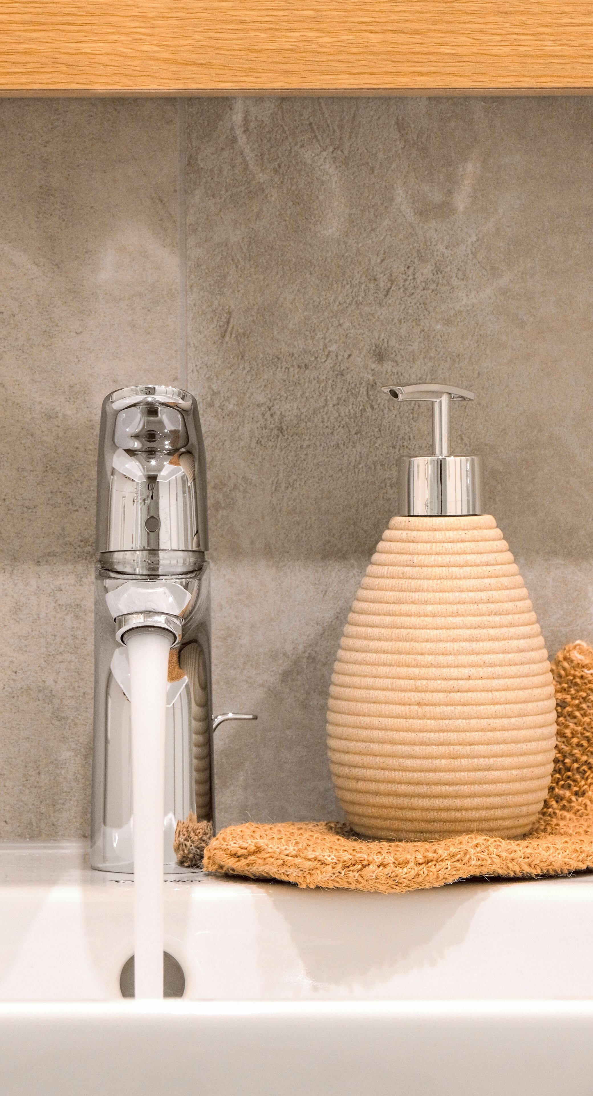 Ein Badezimmer mit einem modernen Wasserhahn und einer Seifenspender.