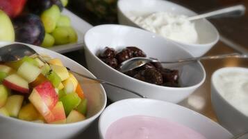 A variety of food items including fruits, yogurt, and a bowl of what appears to be a dessert or sweet dish.