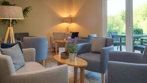 A modern living room with grey sofas, a small wooden table, and a potted plant.