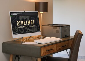 A desk with a desktop computer, a keyboard, a lamp, and a printer.