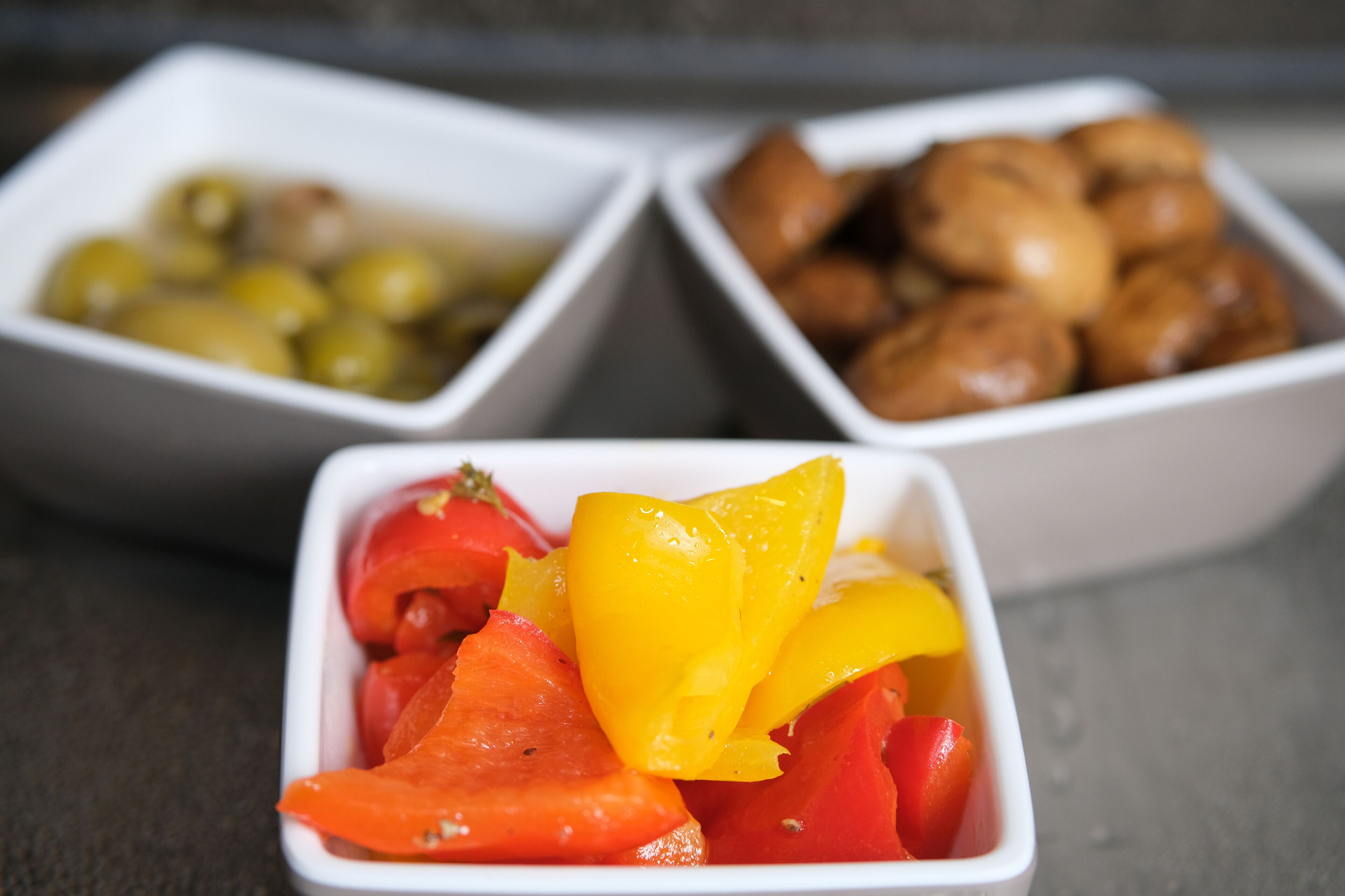 Three white bowls containing different food items.