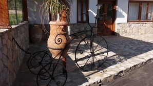 A stone-paved courtyard with a bicycle and a large planter. - Myrtoo (Monemvasia)