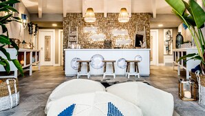 A spacious lobby with a stone wall, a reception desk, and a seating area with a patterned rug. - Boutique Hotel Capo Blu (Pula)
