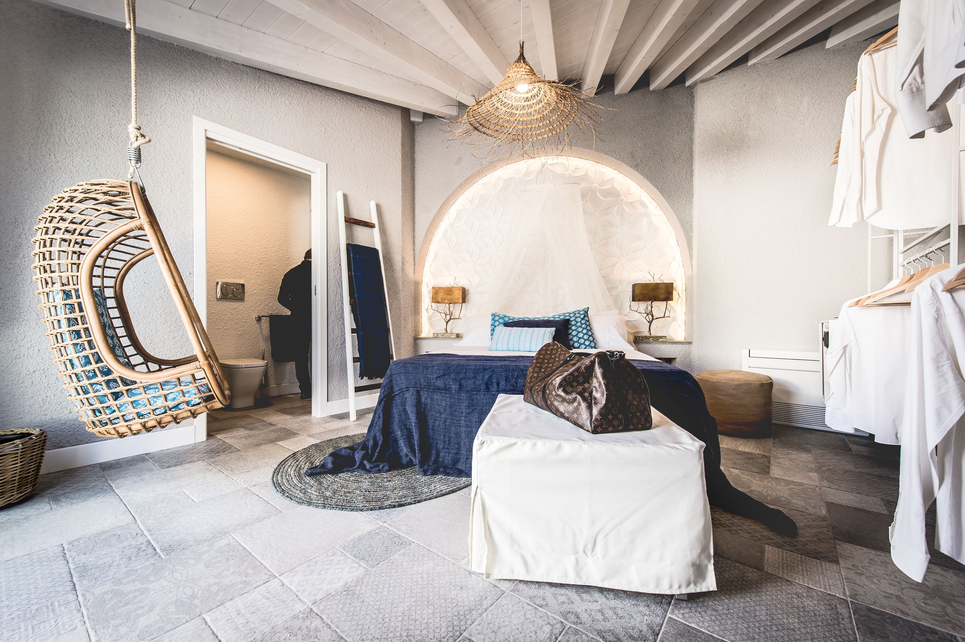 A bedroom with a bed, hanging chair, and a wardrobe.