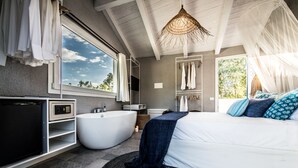 A modern bedroom with a large bed, a bathtub, and a wardrobe. - Boutique Hotel Capo Blu (Pula)
