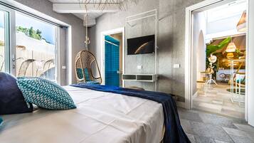 A bedroom with a bed, a hanging chair, a TV, and a view of the outside.