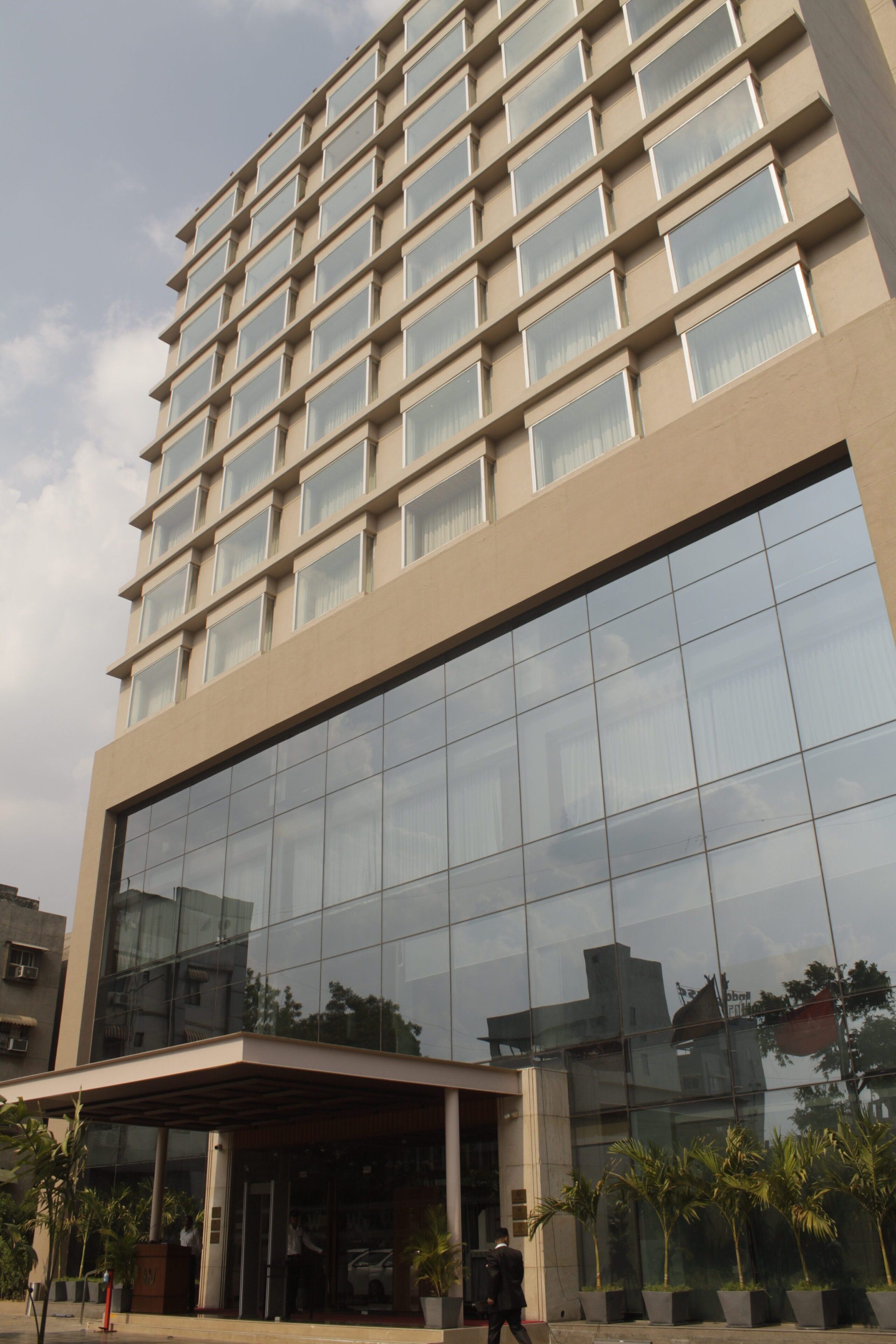 A modern building with a glass facade and a covered entrance.