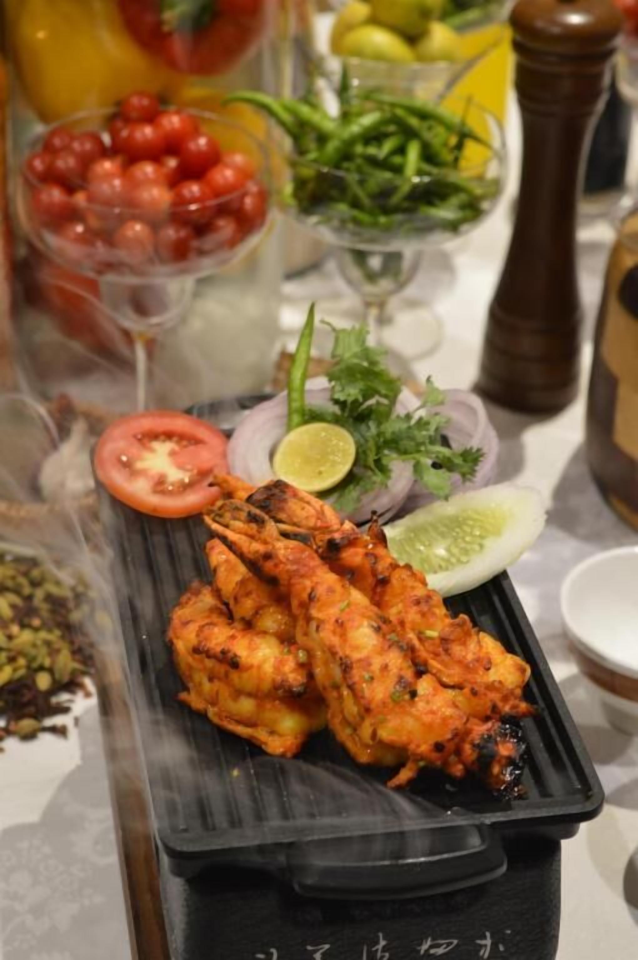 A meal with grilled chicken, tomatoes, onions, and a lime wedge.