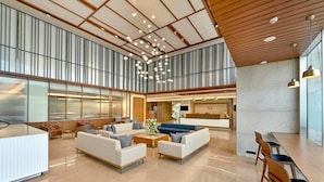 Un hall d’entrée spacieux avec un plafond haut, un mobilier moderne et un espace d’accueil.