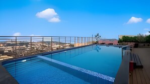 Une piscine à débordement située sur le toit, offrant une vue dégagée sur le paysage urbain.
