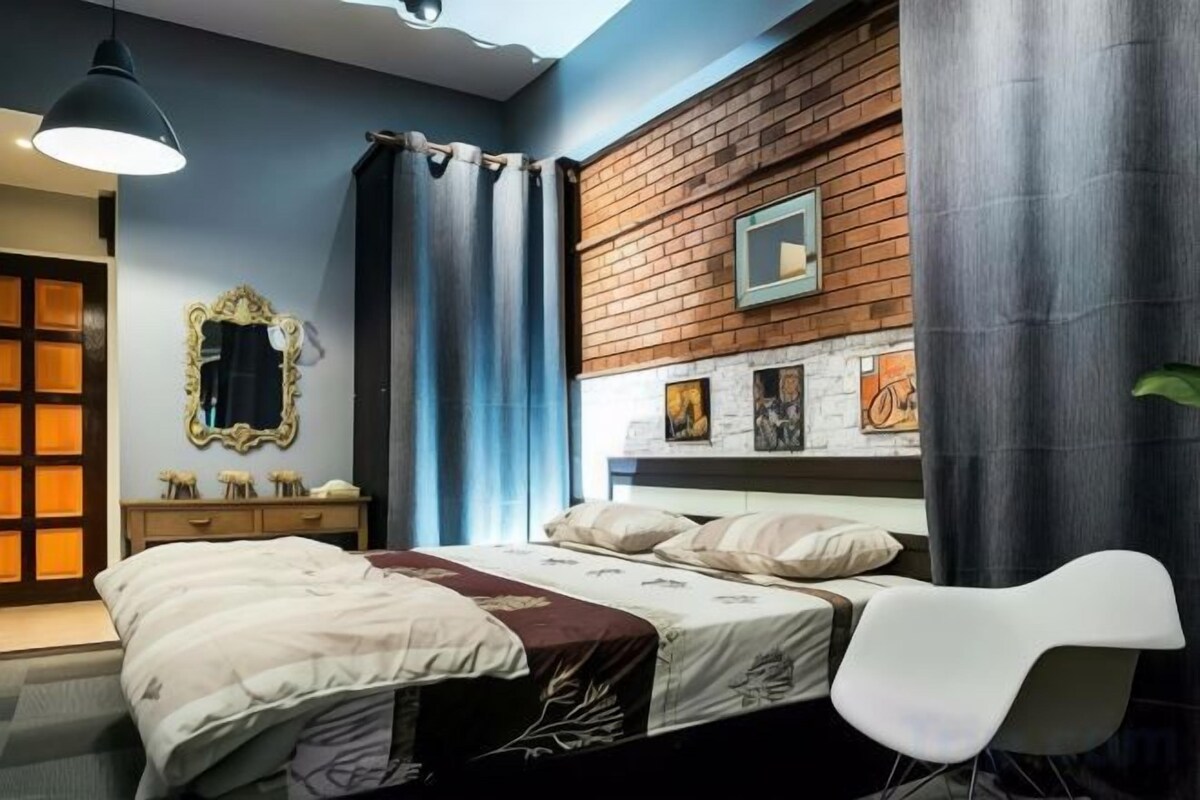Un dormitorio con cama, una silla, cómoda y espejo.