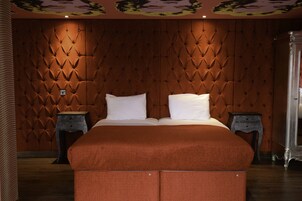Una camera da letto con una testiera trapuntata, un letto grande con due cuscini e due comodini.