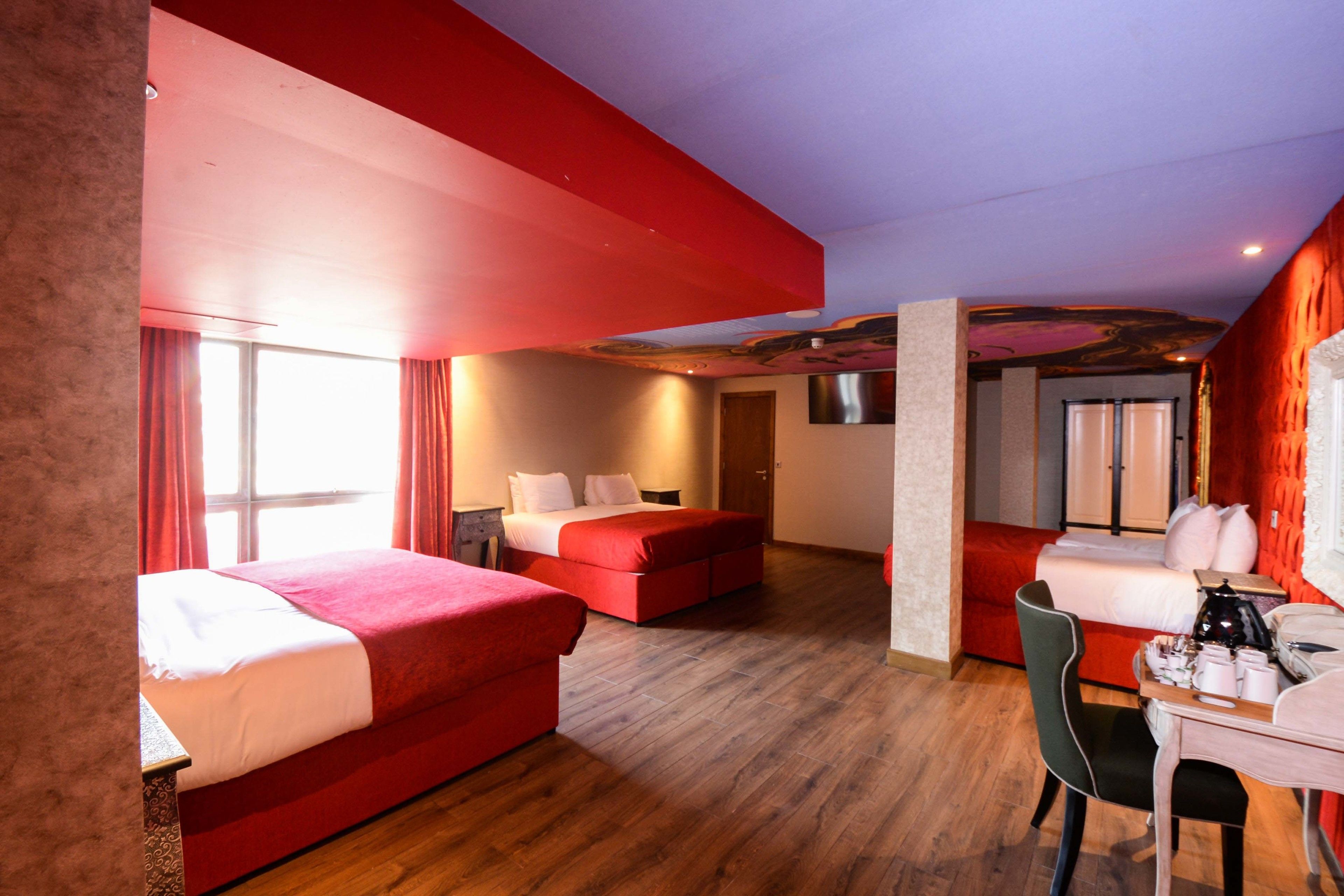 A hotel room with two beds, a desk, and a chair.