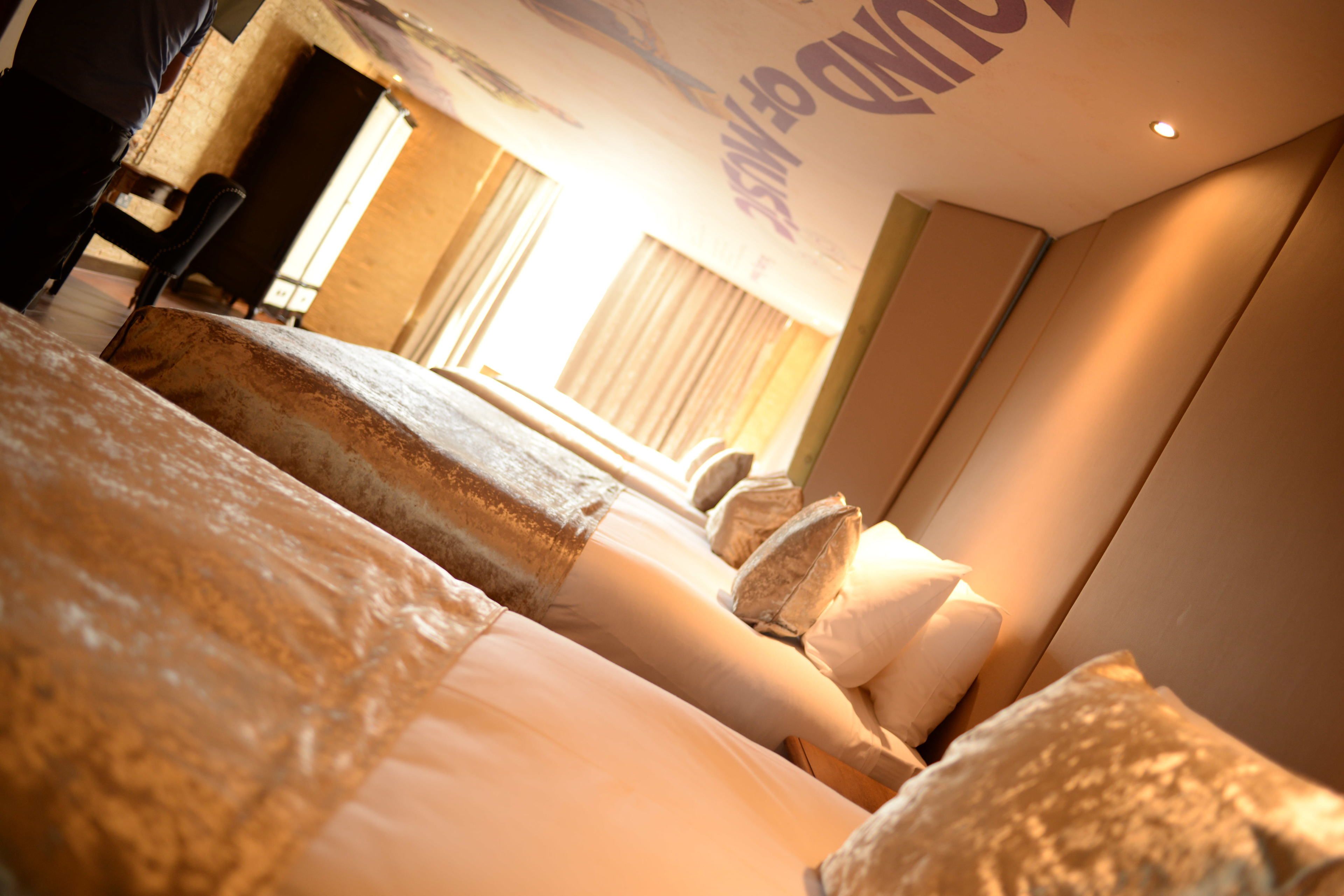 A hotel room with a large bed, a desk, and a chair.