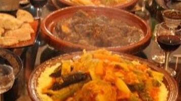 Una mesa con diferentes platos, copas de vino y una botella de agua.