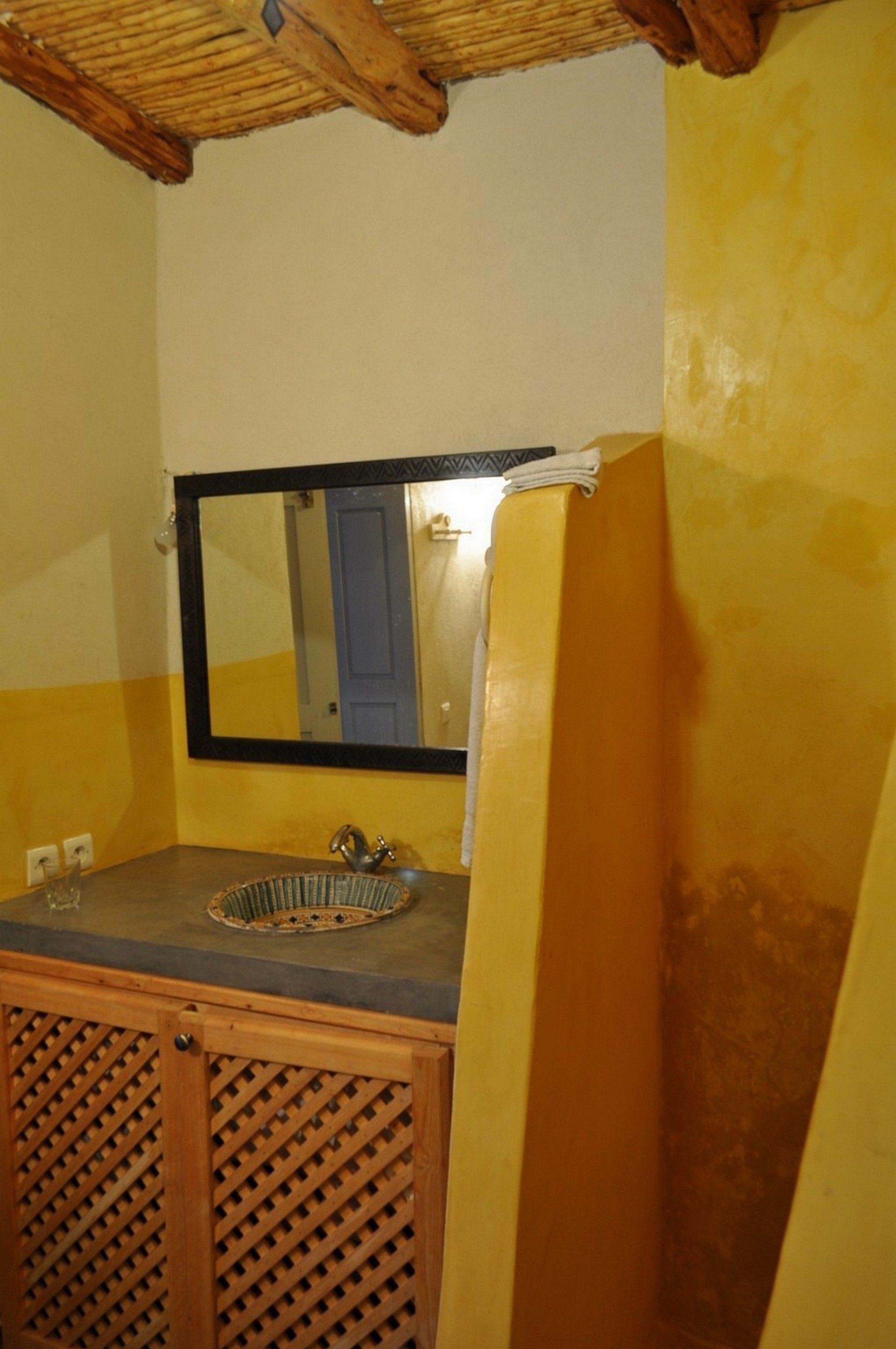 Ein Badezimmer mit Holzschrank, Waschbecken und Spiegel.