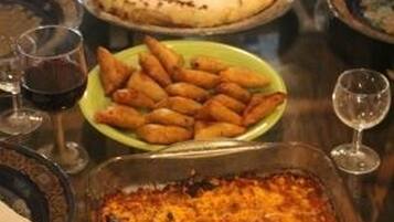 Una mesa de comedor con diferentes platos, entre ellos un pastel de carne, pasteles y una tarta.