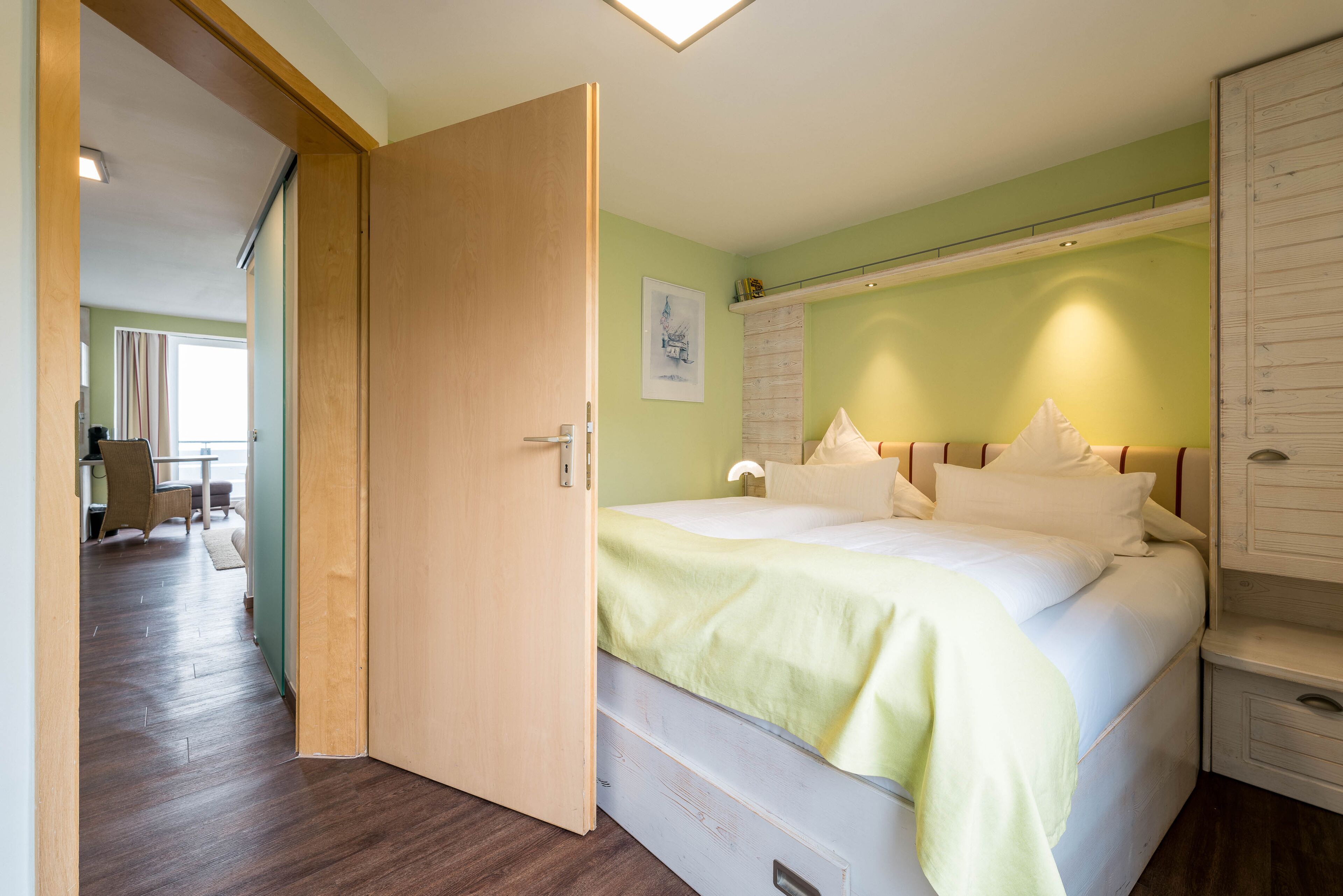A bedroom with a bed, a nightstand, and a wardrobe.