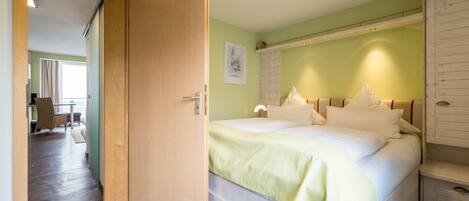 A bedroom with a bed, a nightstand, and a wardrobe.