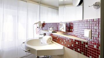 A modern bathroom with a white sink, a towel, a mirror, and a red-tiled backsplash.
