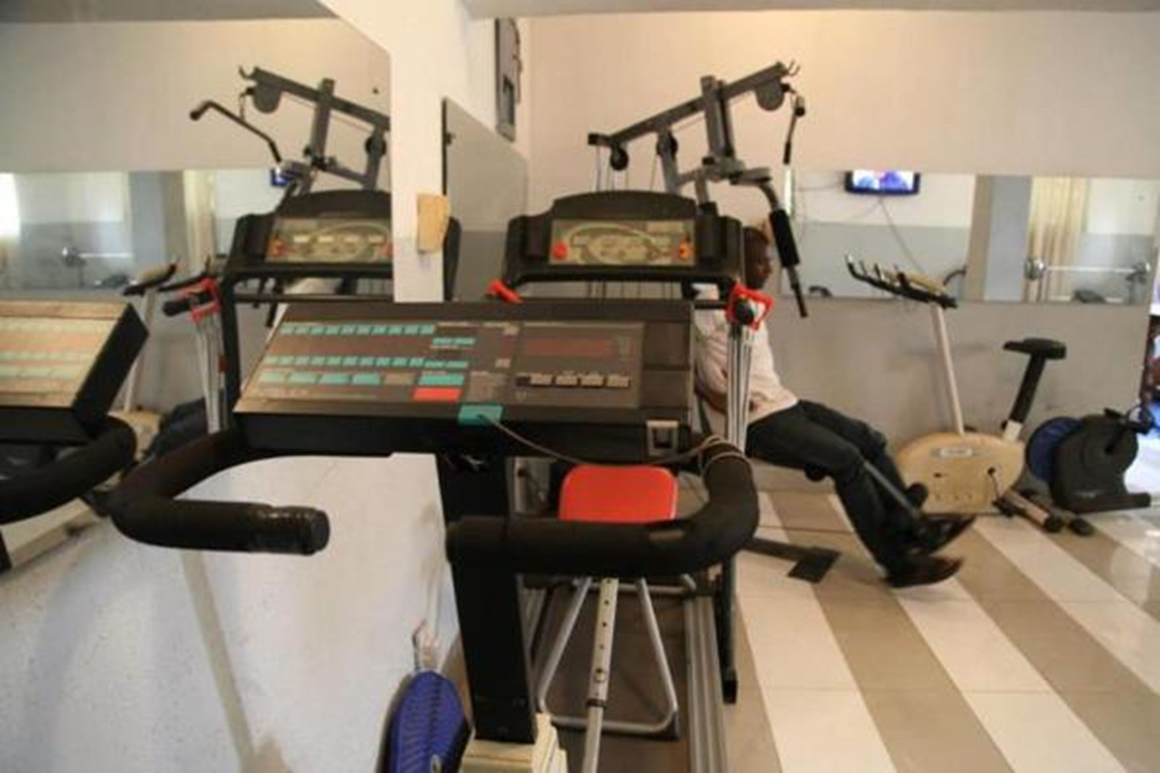 Un gimnasio con equipo de ejercicio, incluyendo cintas de correr y una bicicleta estática.