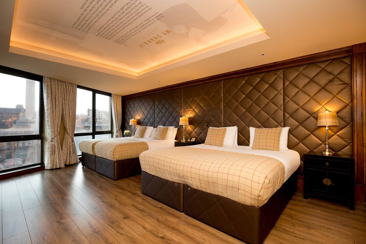 Habitación de hotel con dos camas, vistas a la ciudad y un diseño moderno.