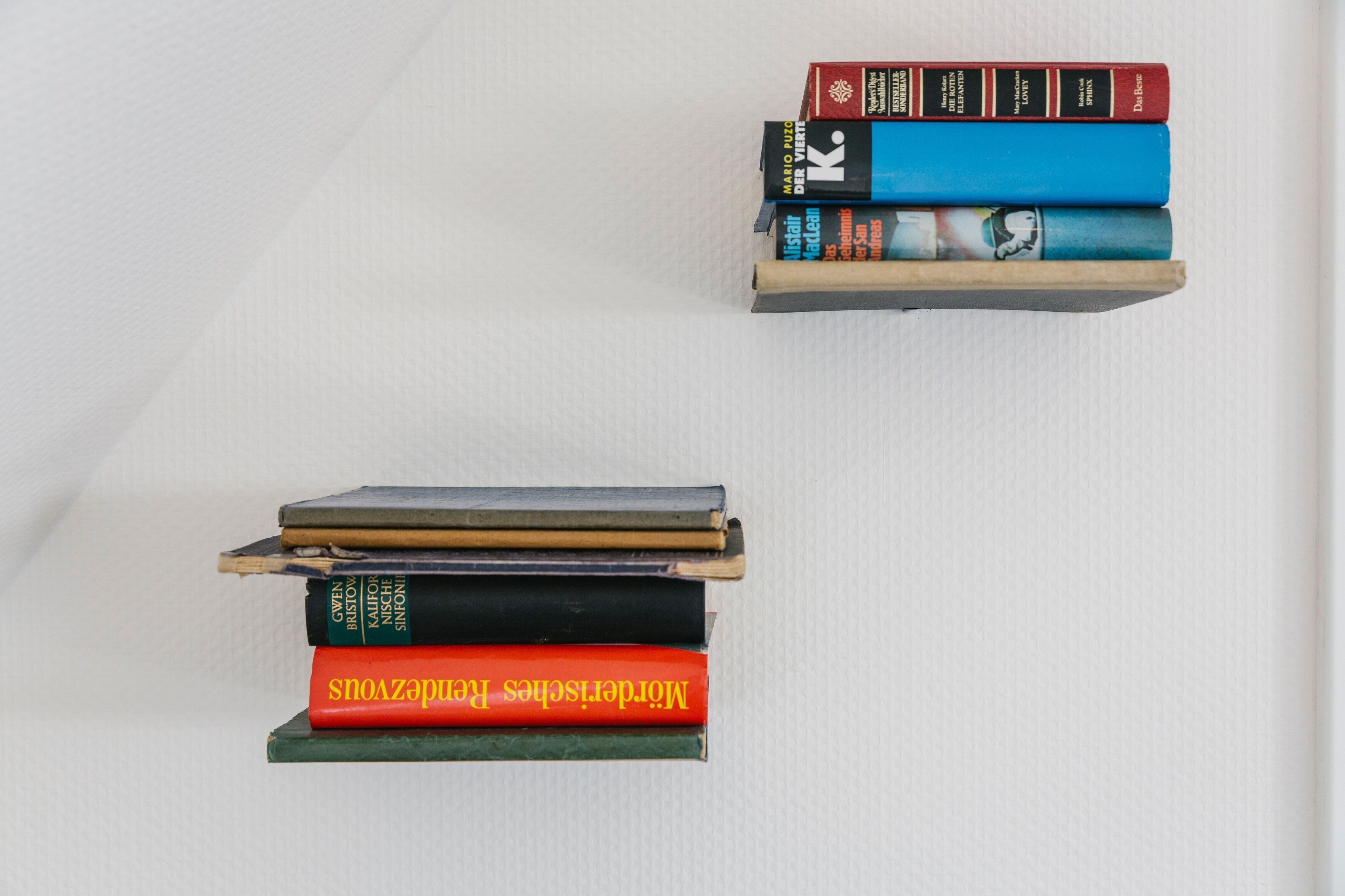Two stacks of books on shelves.