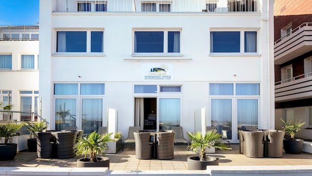 A modern hotel with a white facade, large windows, and a sign reading "Hotel auf einem Hummerklippen". - Hotel auf den Hummerklippen (Helgoland)