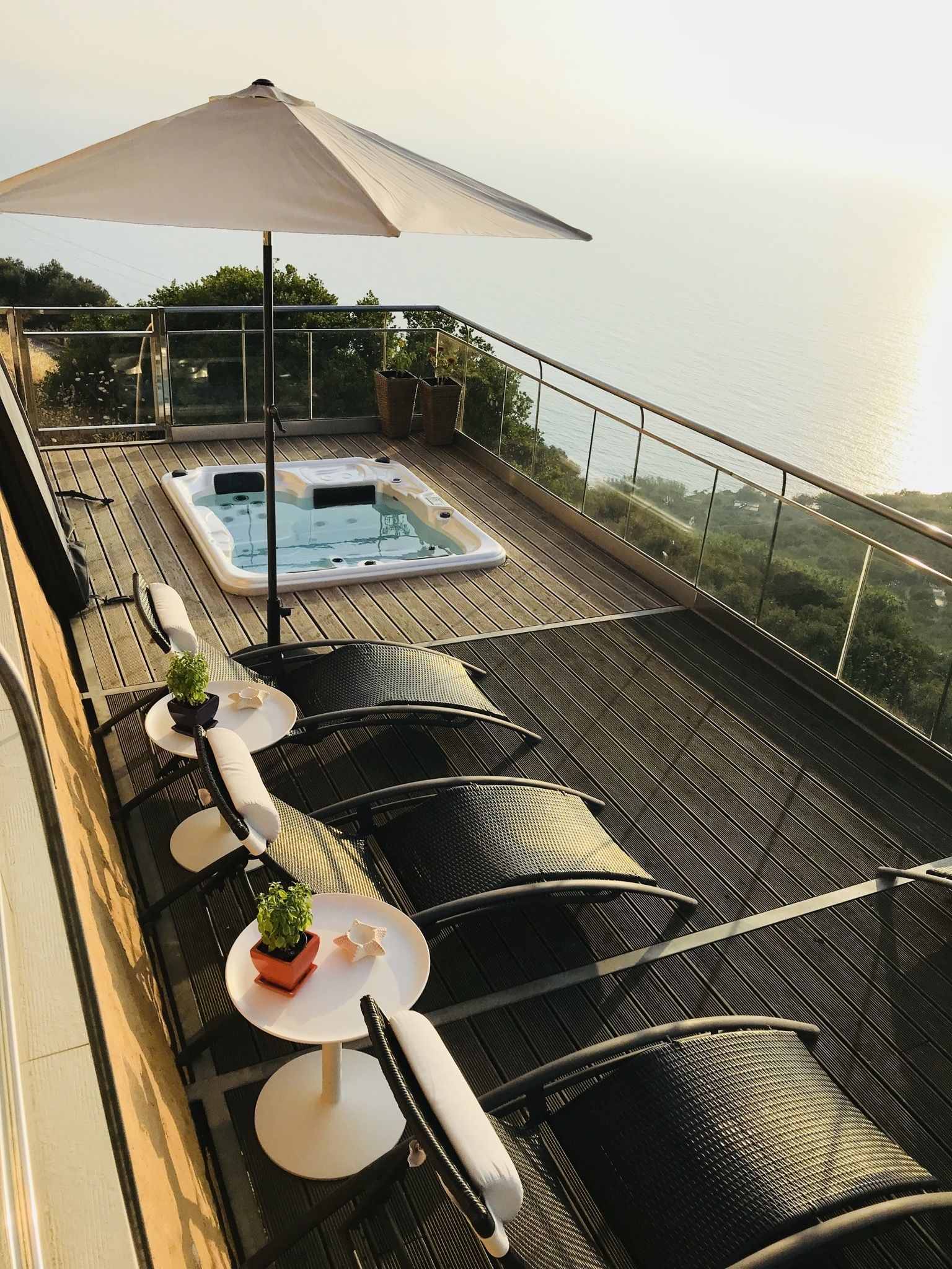 Um terraço no telhado com hidromassagem, área de estar externa e vista para o mar.