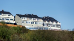 A row of buildings with a sign that reads "Cafe Krebs" and another that says "Felsen-Museum." - Hotel Felsen-Eck (Helgoland)