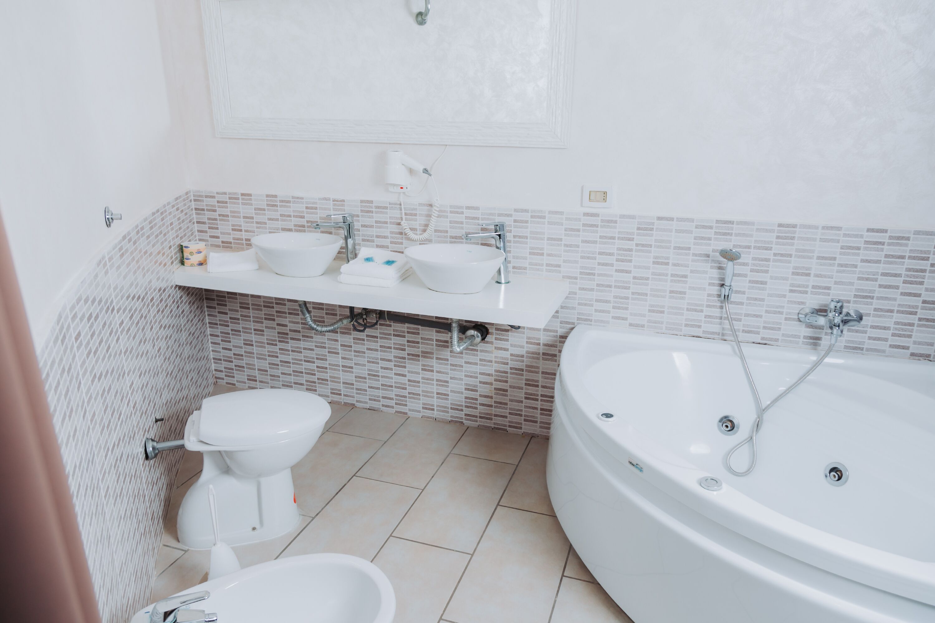 A modern bathroom with a toilet, bidet, and bathtub.