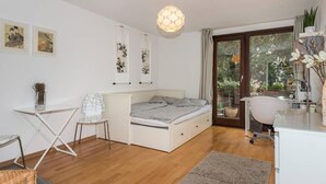 A modern bedroom with a bed, a desk, a chair, and a dining table. - 1 bedroom apartment in prime location (Mannheim)