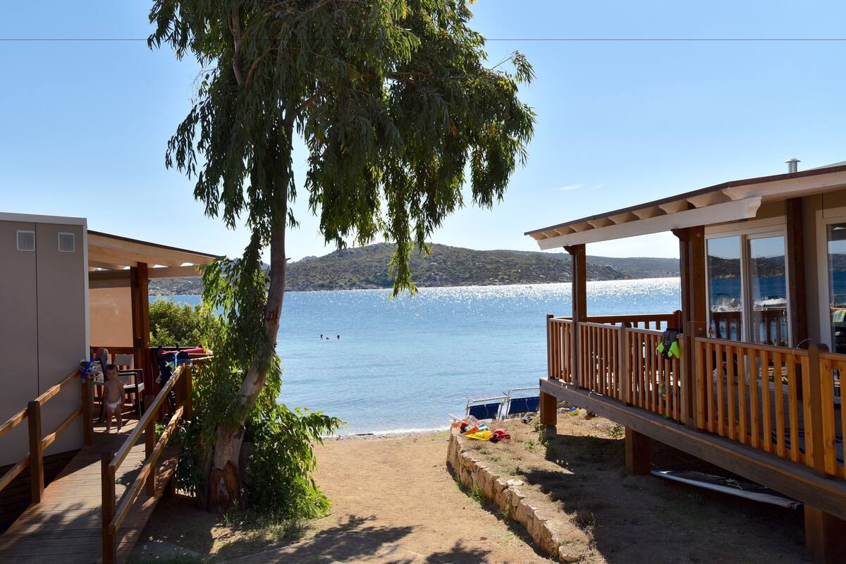 A wooden deck with a view of a lake and mountains.