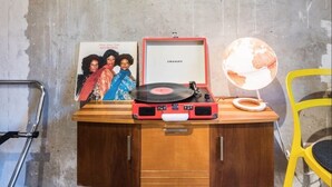 A wooden cabinet with a red turntable, a framed picture, and a globe. - Charming Hipster Flat (Mannheim)