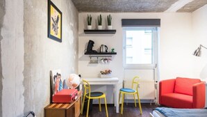 A compact room with a white desk, two yellow chairs, a red sofa, and a radiator. - Charming Hipster Flat (Mannheim)