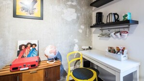 A kitchen with a concrete wall, a globe, a red suitcase, a yellow chair, and a coffee machine. - Charming Hipster Flat (Mannheim)